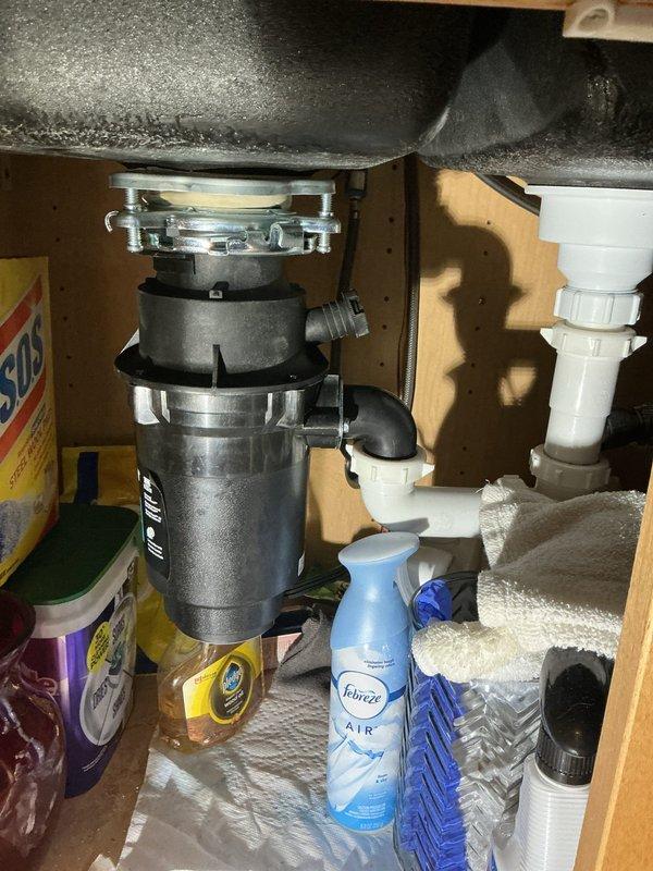 Responded to water leak complaint with water present on basement floor and doubled water bill. Conducted thorough inspection of plumbing system including water heater, main supply lines, and fixture connections. Inspected basement piping assembly showing age-related corrosion and rust on metal pipes and fittings. Examined kitchen sink plumbing including garbage disposal unit and PVC drainage connections for potential leak sources. Traced water supply lines and shut-off valves throughout affected areas. Identified leak source and completed necessary repairs to stop active water loss. Verified all connections were secure and tested system operation to ensure proper function. Documented conditions with photographs for service records.