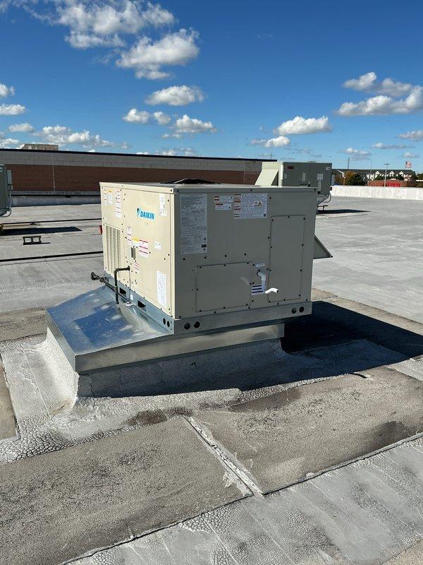 Successfully installed a 4-ton Daikin rooftop package unit on commercial building. Unit was mounted on elevated curb adapter with proper platform support, electrical conduit and refrigerant lines connected per manufacturer specifications, and all technical components secured for optimal operation.