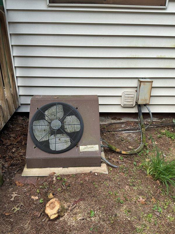 Completed AC retrofit at residential property involving assessment and documentation of existing HVAC system configuration. Inspected and photographed basement heating unit with connected ductwork and outdoor condensing unit showing age-related wear. Documented current equipment placement, electrical connections including disconnect box, and system layout to prepare comprehensive replacement estimate for aging air conditioning system.