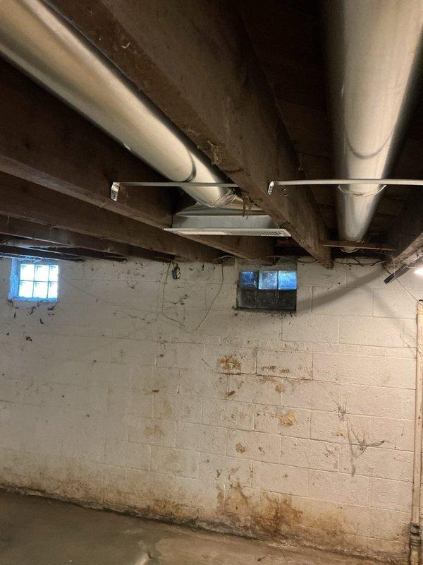 Completed new construction HVAC installation in basement utility area, including furnace and complete ductwork system. Installed horizontal metal supply ductwork running across exposed ceiling joists with proper register placement, ensuring adequate airflow distribution throughout the structure. All components installed to code specifications and system tested for proper operation.