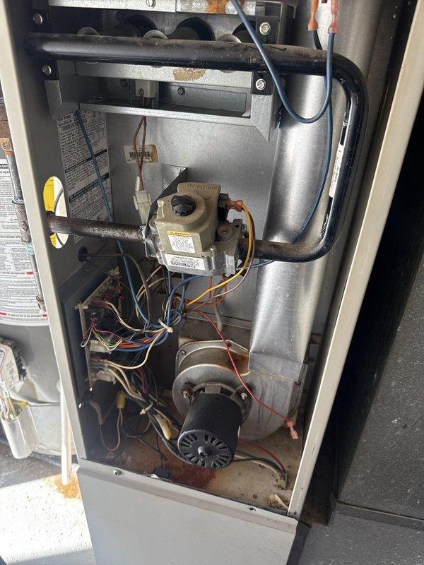 Performed comprehensive heating maintenance on gas furnace system. Removed access panel and inspected internal components including gas valve assembly, draft inducer motor, and burner assembly. Cleaned all accessible components, removing dust and debris accumulation from motor housing and interior surfaces. Conducted combustion analysis using Testo 327-1 analyzer, recording oxygen levels at 10.1%, efficiency at 82.9%, and carbon monoxide readings at 15 PPM ambient with 0 PPM in flue gas, confirming safe and efficient operation. Verified all electrical connections to gas valve and inducer motor were secure. Reinstalled access panel and secured unit upon completion. System operating within normal parameters.