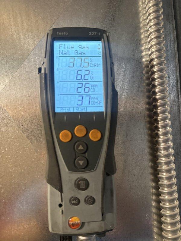 Performed seasonal heating maintenance on an 11-year-old natural gas furnace, removing the upper access panel to inspect the burner compartment, gas valve assembly, wiring harness, and blower motor. Conducted flue gas combustion analysis, recording 6.2% O2, 26 ppm CO, and 37 ppm CO air-free at 37.5% excess air, confirming combustion within acceptable parameters. Noted dust accumulation and light corrosion on the cabinet floor of the interior compartment, which should be monitored at future visits.