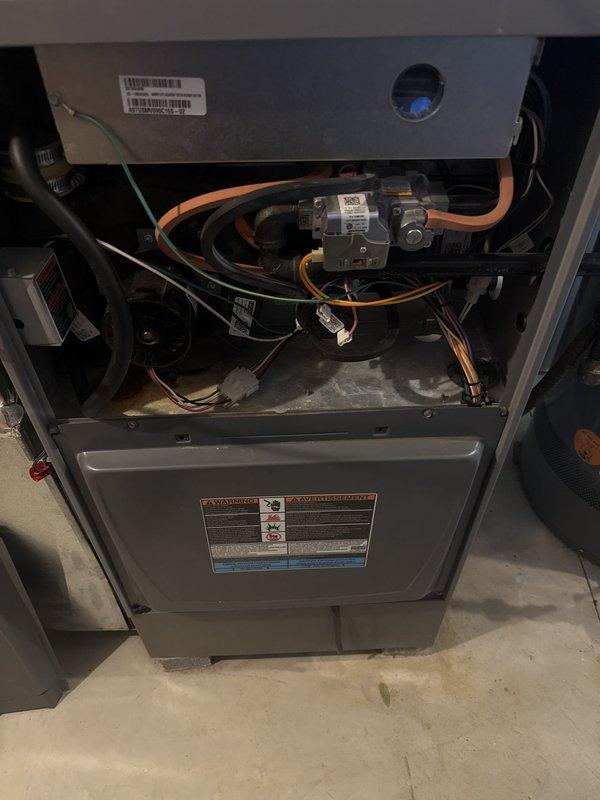 Performed seasonal heating maintenance on an 11-year-old natural gas furnace, removing the upper access panel to inspect the burner compartment, gas valve assembly, wiring harness, and blower motor. Conducted flue gas combustion analysis, recording 6.2% O2, 26 ppm CO, and 37 ppm CO air-free at 37.5% excess air, confirming combustion within acceptable parameters. Noted dust accumulation and light corrosion on the cabinet floor of the interior compartment, which should be monitored at future visits.