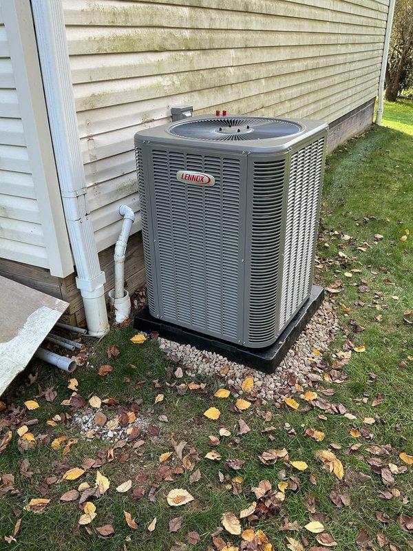 Completed a full HVAC system installation, including a new Lennox outdoor condenser unit set on a composite pad with properly routed refrigerant line set, electrical disconnect, and flexible conduit connections. The system supplies a full-capacity unit serving the garage and a half-capacity unit serving the house, with condensate drainage terminated to a PVC drain stub away from the foundation. Unit was left clean and secure with no visible damage.