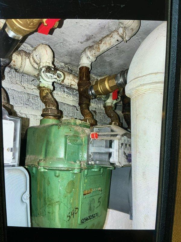 Installed shutoff valves on the gas piping serving a multi-meter manifold in the basement utility area, connecting flexible gas lines with brass fittings and red-handled isolation valves to each meter. Verified secure connections and proper valve operation at each meter location, with piping routed overhead to the meter bank.