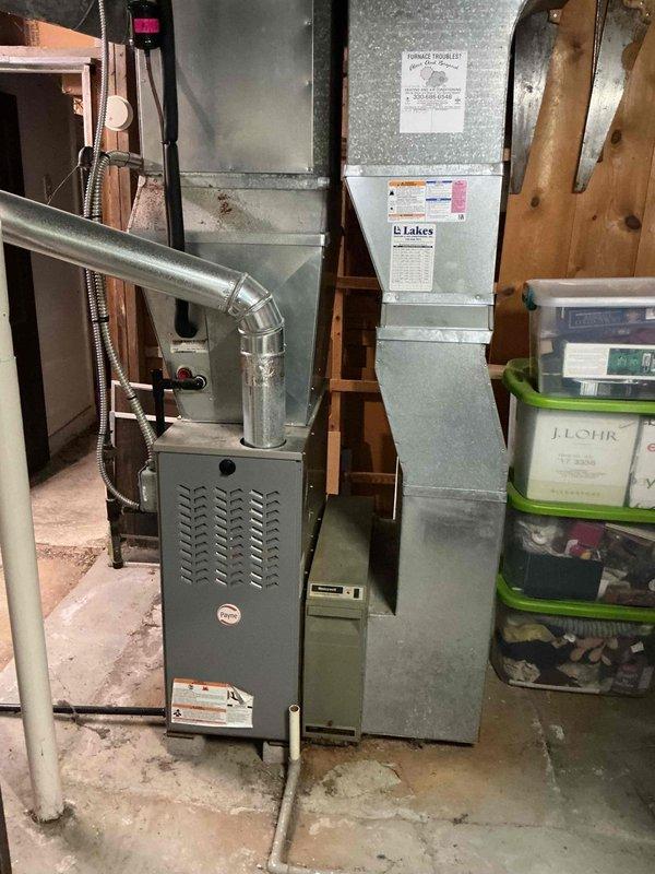 Performed scheduled commercial heating maintenance on a Payne gas furnace, inspecting the furnace cabinet, flue vent connection, supply plenum, and ductwork, and verifying operation of the Honeywell control. Took temperature readings at the ductwork using a handheld digital thermometer to evaluate system performance. Noted dust and debris buildup on the furnace and surrounding area, with no operational deficiencies documented.