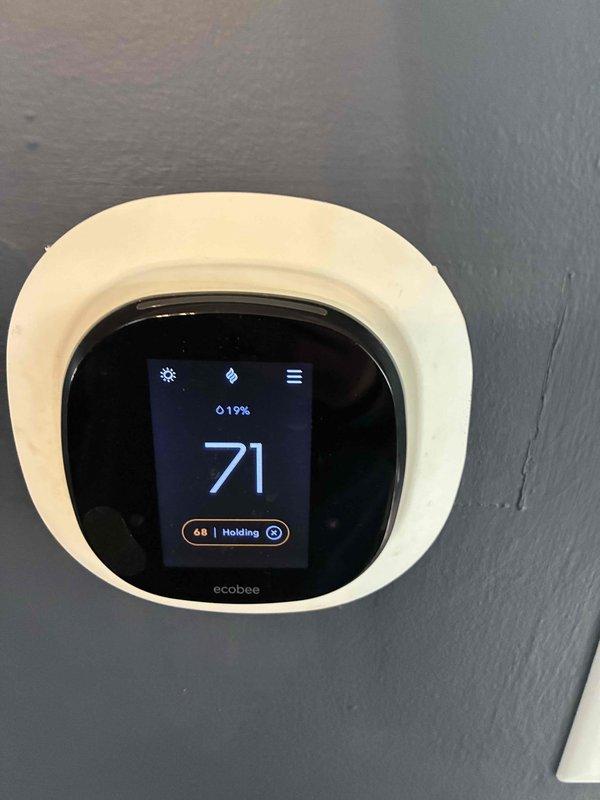 Installed new ecobee smart thermostat as requested by customer. Verified operation and confirmed temperature calibration, noting a 2.8°F differential between thermostat reading (72°F) and calibrated PDT650 digital thermometer (74.8°F). System functioning properly with thermostat maintaining set temperature of 68°F in "Holding" mode.