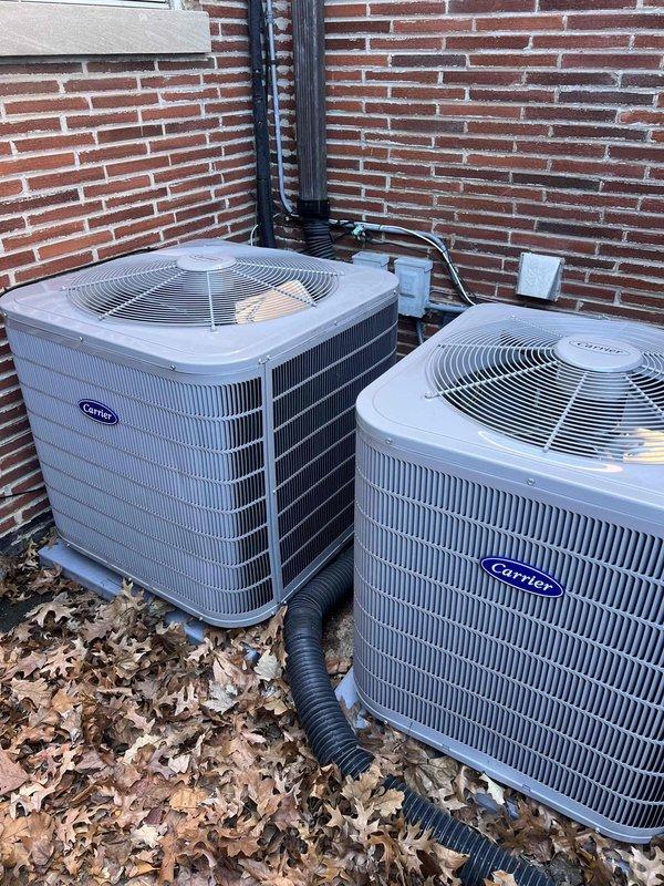 Completed warranty service call for dual Carrier A/C system installation. Verified proper installation of two outdoor condensing units on concrete pads with appropriate clearances and electrical connections. Confirmed indoor air handler installation in attic space with proper ductwork, drainage, and venting systems. All units operational with manufacturer specifications.