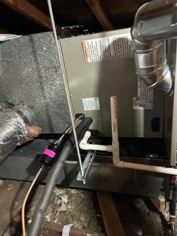 Completed warranty service call for dual Carrier A/C system installation. Verified proper installation of two outdoor condensing units on concrete pads with appropriate clearances and electrical connections. Confirmed indoor air handler installation in attic space with proper ductwork, drainage, and venting systems. All units operational with manufacturer specifications.