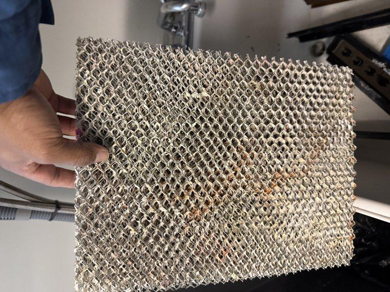 Responded to no-heat call for system less than 10 years old. Discovered humidifier leaking which had tripped the safety device and shut down the furnace. Inspected and replaced the clogged humidifier filter pad which showed significant mineral buildup, and adjusted the humidistat from near-off position to appropriate setting for current outside temperature.