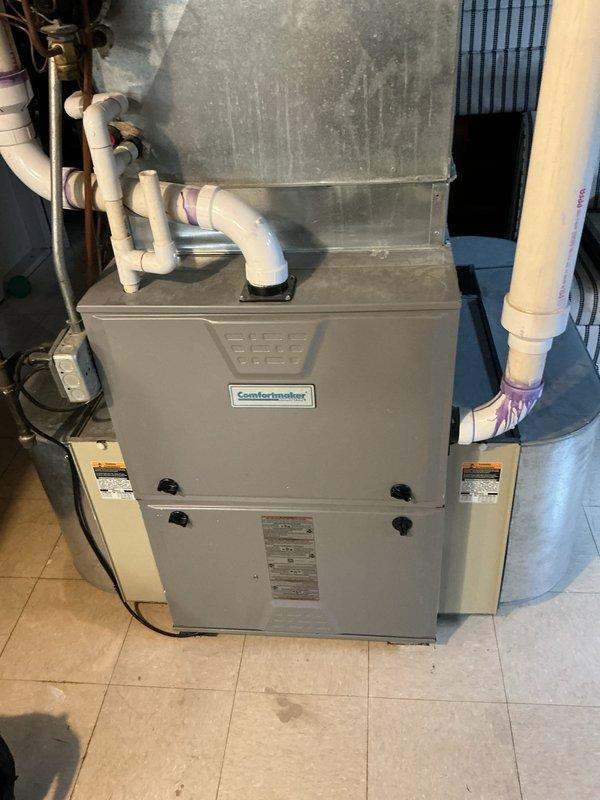 Responded to no heat call for 10+ year old Comfortmaker furnace. Diagnostic found system with blower operating but no heat production and thermostat displaying alert. Determined cause was failed flame sensor, cleaned and reinstalled component which restored proper ignition sequence and heating function.