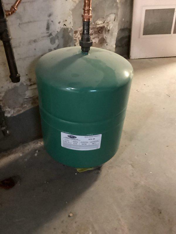 Performed routine maintenance inspection on boiler and water heater per service agreement. Examined expansion tanks (blue PROFLO tank and green pressure tank) connected to copper plumbing system. Both tanks appear to be functioning properly with no signs of leakage at connection points, though noted some moisture staining on nearby wall that should be monitored.