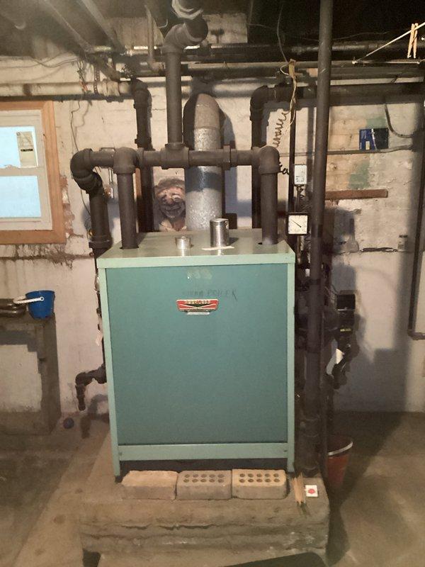 Responded to service call for non-functioning boiler. Inspected aging light blue boiler unit mounted on concrete platform with extensive black piping system. Determined unit has reached end of useful life and requires replacement; customer advised of findings.