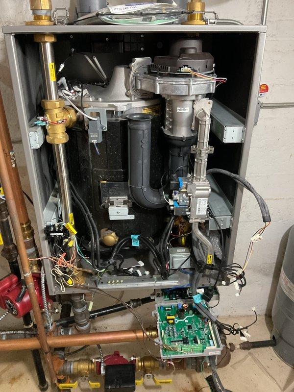 Replaced failed ignitor (under part warranty) and degraded flame sensor on Navien heating system. Accessed internal components by removing front panel to perform the repair. Proper operation of ignition system and flame detection verified after installation.