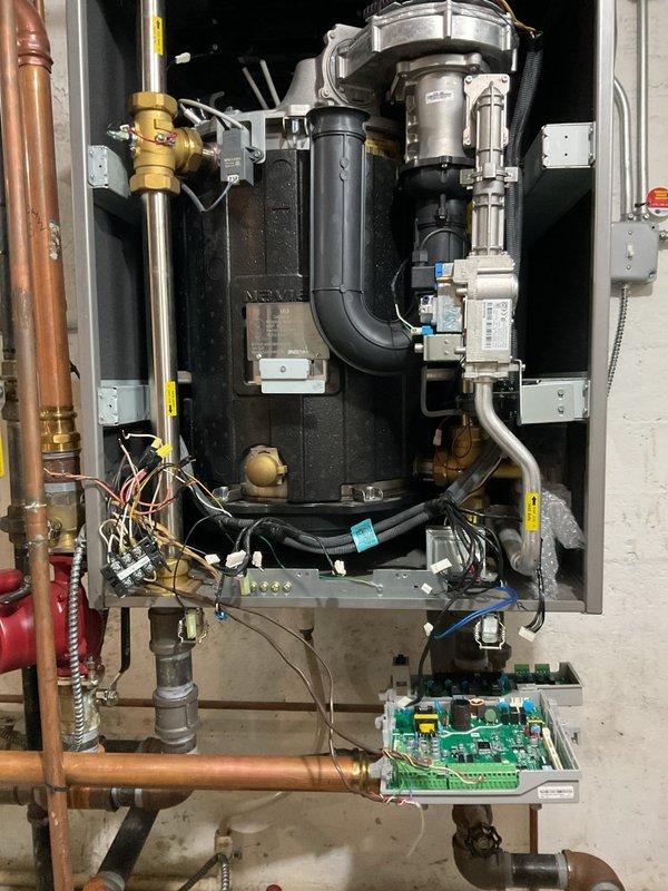 Replaced failed ignitor (under part warranty) and degraded flame sensor on Navien heating system. Accessed internal components by removing front panel to perform the repair. Proper operation of ignition system and flame detection verified after installation.