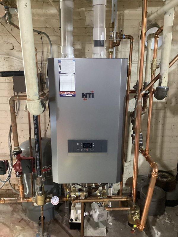 Responded to emergency service call for an inoperative 2-year-old NTi boiler system. Diagnosed and repaired system failure, restoring proper heating function to the residence. Documented complete heating system configuration including circulation pumps, copper piping network, and ventilation components.
