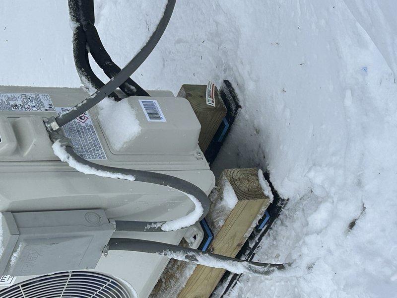 Responded to noise complaint on recently installed outdoor heat pump unit. Discovered unit was experiencing excessive vibration due to snow accumulation around base and on top of condenser. Cleared snow from unit and surrounding area, adjusted wooden mounting blocks for proper leveling, and verified proper operation with reduced noise levels after service.