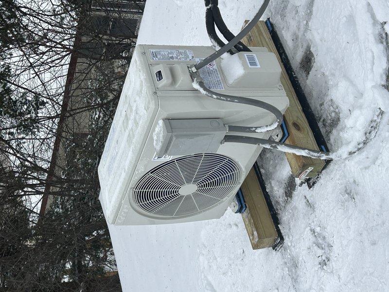 Responded to noise complaint on recently installed outdoor heat pump unit. Discovered unit was experiencing excessive vibration due to snow accumulation around base and on top of condenser. Cleared snow from unit and surrounding area, adjusted wooden mounting blocks for proper leveling, and verified proper operation with reduced noise levels after service.