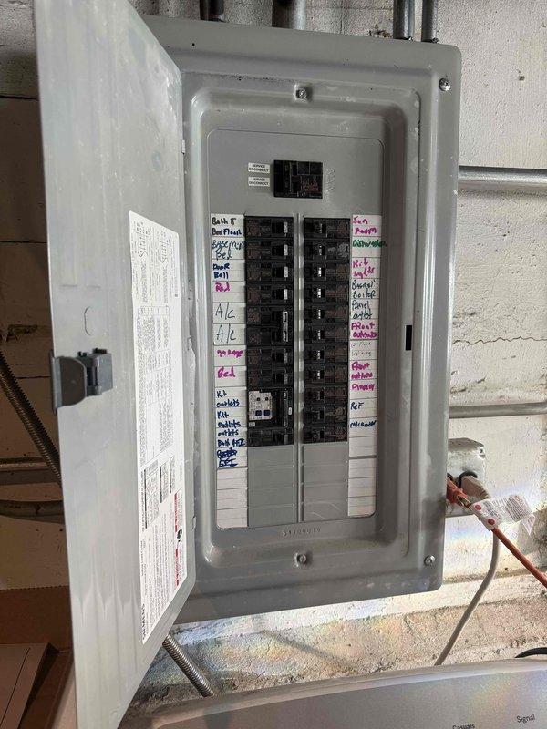 Conducted comprehensive assessment for AC replacement quote, including inspection of electrical panel with circuit breakers labeled for HVAC systems and examination of attic installation area with exposed wooden structure and existing ventilation access. Photos documented current electrical capacity and installation space to ensure proper system specifications for the replacement unit.
