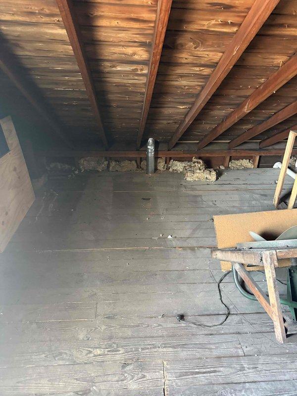 Conducted comprehensive assessment for AC replacement quote, including inspection of electrical panel with circuit breakers labeled for HVAC systems and examination of attic installation area with exposed wooden structure and existing ventilation access. Photos documented current electrical capacity and installation space to ensure proper system specifications for the replacement unit.