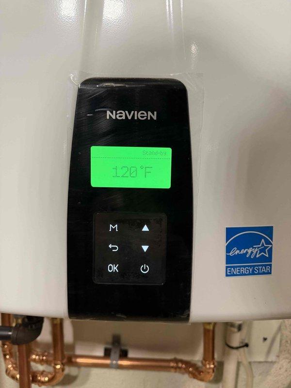 Successfully completed conversion from traditional water heater to a Navien tankless system. Installed new unit with proper venting through exterior PVC pipes and connected to existing gas line with appropriate fittings. System was tested and confirmed operational with temperature set to 120°F, meeting Energy Star efficiency standards.