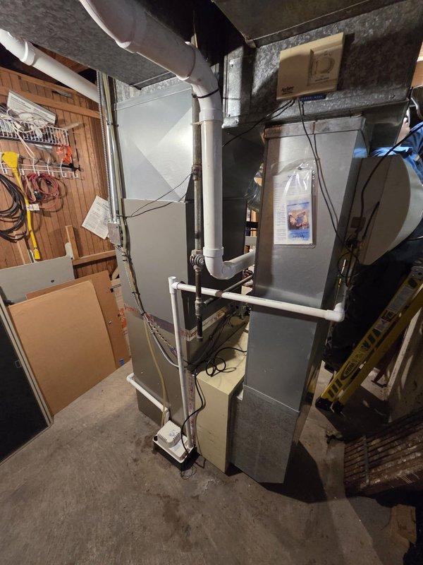 Successfully completed installation of new furnace unit in basement utility room. Installed system includes proper connections to existing ductwork, PVC ventilation/drainage pipes, and electrical components. All manufacturer specifications were followed and the unit is functioning correctly with proper clearances maintained.