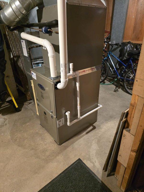 Successfully completed installation of new furnace unit in basement utility room. Installed system includes proper connections to existing ductwork, PVC ventilation/drainage pipes, and electrical components. All manufacturer specifications were followed and the unit is functioning correctly with proper clearances maintained.