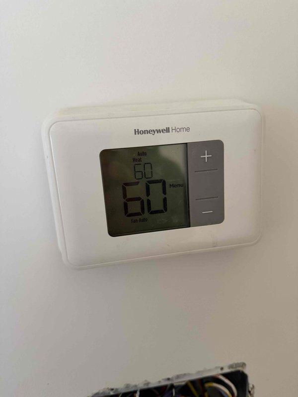 Conducted on-site assessment for complete HVAC system replacement at residential property. Evaluated existing 28-year-old furnace and air conditioning system that has reached end of serviceable life. Documented current thermostat configuration showing Honeywell Home digital unit and photographed exterior condensing unit location with existing electrical disconnect and refrigerant line set routing. Provided comprehensive replacement estimate for new heating and cooling equipment installation.
