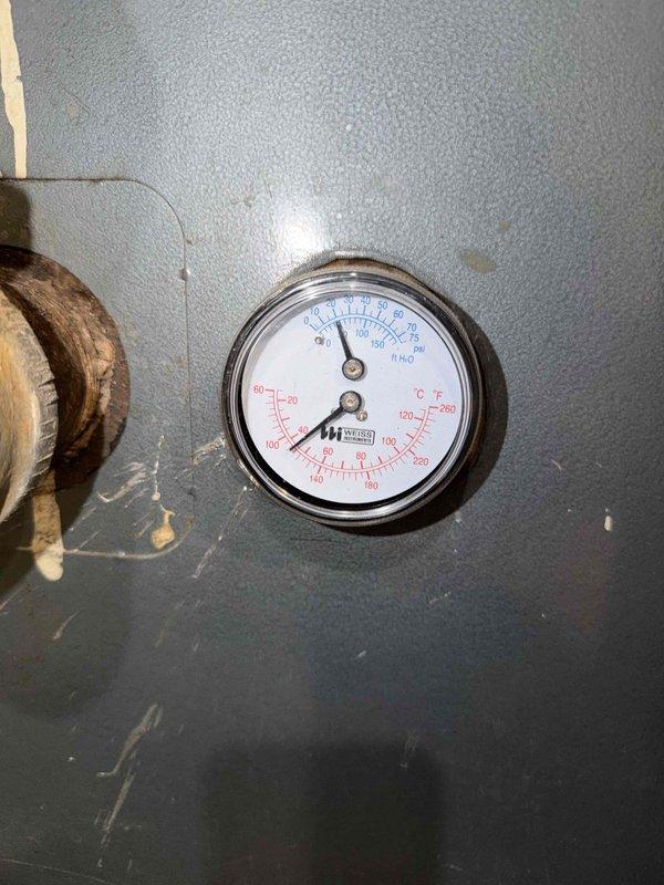 Performed comprehensive maintenance inspection on commercial boiler system under preventative maintenance agreement. Monitored and documented system pressure and temperature readings via dual-scale gauge, confirming operational parameters within manufacturer specifications. Inspected boiler components including pressure relief connections and piping systems, noting normal wear patterns consistent with equipment age. Evaluated heat exchanger assembly and identified significant frost accumulation on evaporator coil fins and refrigerant distribution headers, indicating potential airflow restriction or system imbalance requiring attention. Captured photographic documentation of gauge readings and frost buildup conditions for service records and future reference.