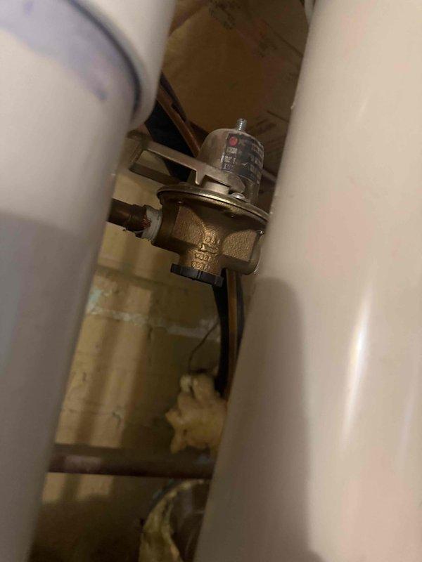 Conducted on-site evaluation of non-functioning boiler system over 20 years old for replacement assessment. Inspected existing combination boiler unit, associated plumbing components including brass pressure regulator valve and aged supply piping showing mineral deposits and discoloration. Documented current HVAC infrastructure including insulated ductwork and air handler components in utility space. Provided comprehensive estimate for boiler replacement and discussed options for concurrent air conditioning unit replacement to address both heating and cooling system upgrades.