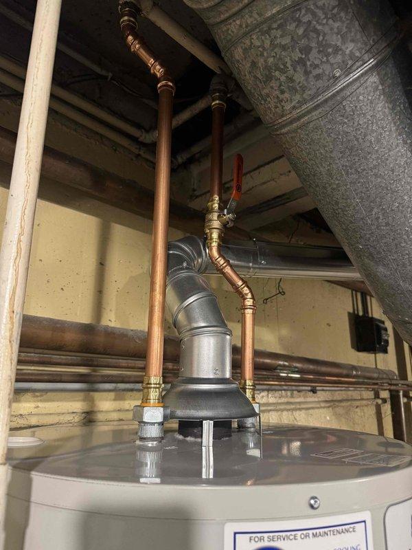 Completed water heater replacement in residential utility area. Removed existing tanked water heater unit and installed new replacement model with proper copper supply line connections and brass shut-off valves. Verified all plumbing connections for proper seal integrity, ensured adequate clearances per manufacturer specifications, and tested unit operation upon completion. New installation includes properly configured hot and cold water supply lines with appropriate valve access for future maintenance requirements.