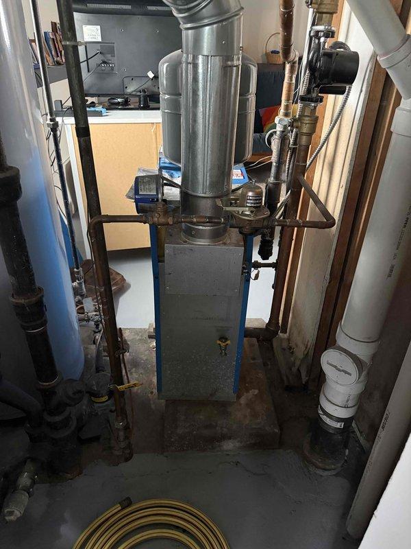 Conducted boiler replacement estimate for 20-year-old existing system. Inspected current boiler installation in basement mechanical room, documenting equipment configuration including existing ductwork, copper piping distribution, and air handling components. Observed frost accumulation on copper supply lines at junction points, indicating potential insulation deficiencies or system operational issues. Evaluated mechanical room layout, existing piping infrastructure including copper supply lines and PVC drainage, electrical service panel access, and overall system integration. Photographed equipment for replacement specifications and provided homeowner with recommendations for new boiler installation.