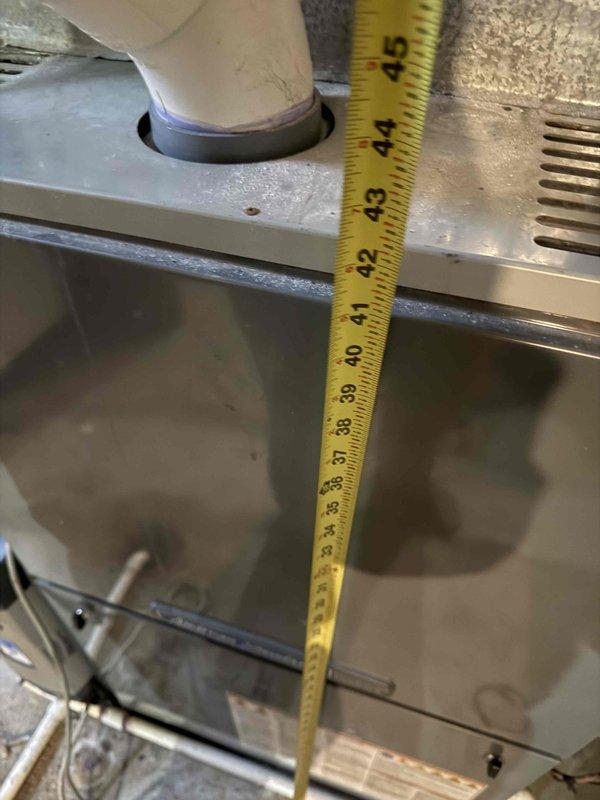 Provided comprehensive replacement estimate for 15-year-old American Standard furnace system located in basement mechanical room. Unit diagnosed with cracked heat exchanger and multiple major component failures requiring full system replacement. Documented existing equipment configuration including PVC venting system, electrical connections, and clearance measurements to ensure proper specifications for new installation.