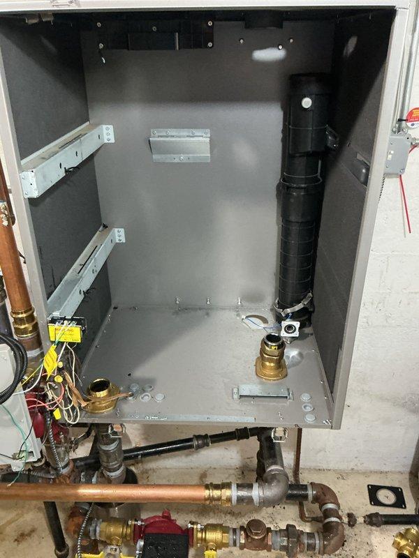 Replaced warranty heat exchanger on Navien boiler system. Disassembled unit housing, removed failed heat exchanger assembly along with circulation motor and associated wiring connections, and installed new warranty replacement heat exchanger. Reconnected all electrical components including motor wiring and plumbing connections, verified proper operation of gas valves and water flow, and reassembled cabinet enclosure to complete repair.