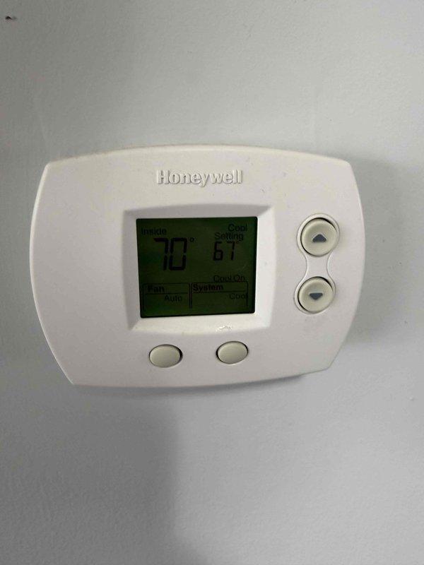 Completed air conditioning maintenance agreement inspection. Verified thermostat operation showing 70°F ambient temperature with cooling setpoint at 61°F. Accessed and inspected blower assembly, documenting significant dust and debris accumulation on blower wheel, housing interior, and base platform requiring attention for optimal system performance.