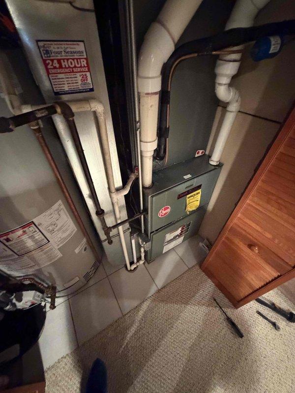 Conducted comprehensive assessment of existing HVAC system for heating unit replacement at residential property. Evaluated current Rheem furnace installation located in basement utility area alongside water heater. Performed dimensional measurements of outdoor air conditioning equipment to ensure proper sizing compatibility for new system installation. Documented existing equipment configuration including PVC venting, copper refrigerant lines, and current furnace placement within confined utility space.

Prepared detailed replacement estimate for two heating units with equipment options. Presented GOOD tier Carrier gas furnace option rated at up to 80% nominal AFUE efficiency and BEST tier Carrier gas furnace option also rated at up to 80% nominal AFUE efficiency. Reviewed existing utility room layout constraints including carpeted flooring, adjacent cabinetry, and current piping configurations to determine installation requirements. Assessed venting pathways and utility connections fo
