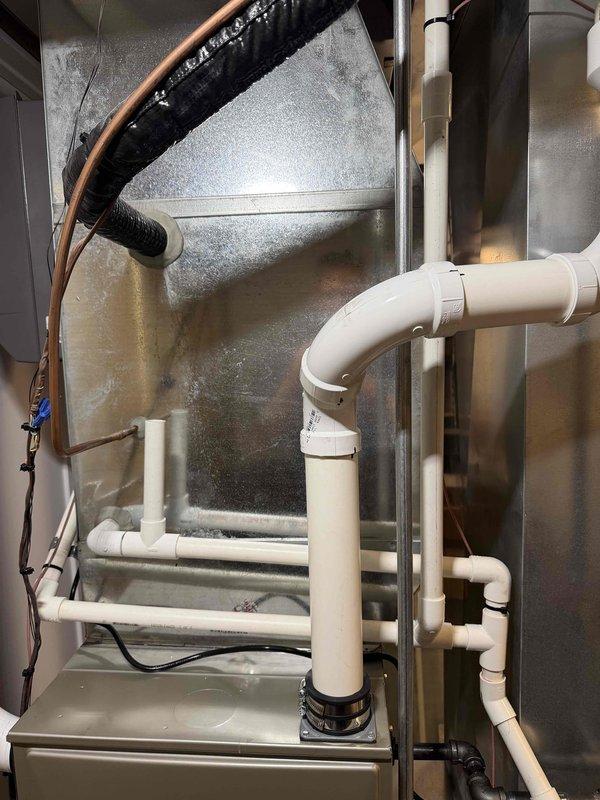 Completed full HVAC system upgrade including removal of existing equipment and installation of new Carrier brand furnace unit. Installed new condensate drain system using white PVC piping with proper pitch and routing for efficient drainage. Connected refrigerant lines with appropriate insulation and secured all ductwork connections to the new furnace plenum. Configured silver metallic supply ductwork and ensured proper sealing at all joints. Installed new thermostat and humidifier as part of the complete system replacement. Verified all electrical connections, tested system operation, and confirmed proper airflow throughout the installation.