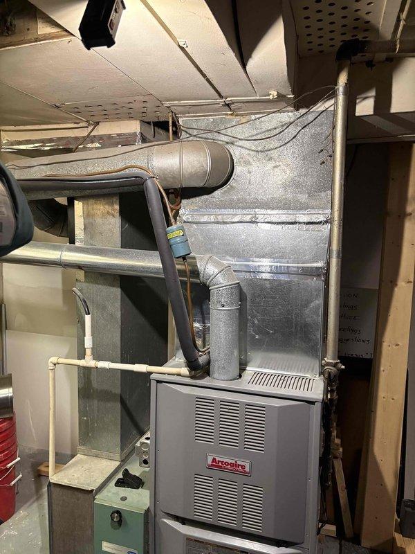 Evaluated 19-year-old HVAC system including R22 air conditioning unit, Arcoaire furnace, thermostat, and humidifier. System currently non-operational and utilizes obsolete R22 refrigerant. Documented equipment condition and accessibility, noting straightforward service access in basement installation. Recommended complete system replacement due to age, refrigerant phase-out, and current shutdown status.