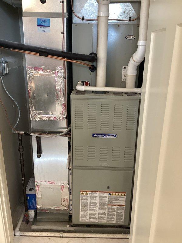 Responded to no cooling complaint on 10+ year old American Standard system with R-410A refrigerant. Performed diagnostic evaluation and discovered upstairs condenser coil showing signs of potential refrigerant leak. Utilized Fieldpiece digital manifold gauges to measure system pressures and confirm low refrigerant charge. Documented equipment model TE31630D175B1605AP and inspected mechanical room installation including furnace, air handler, and associated refrigerant lines. Customer advised of findings and recommended further leak detection testing to determine exact location and extent of coil damage before proceeding with refrigerant recharge.