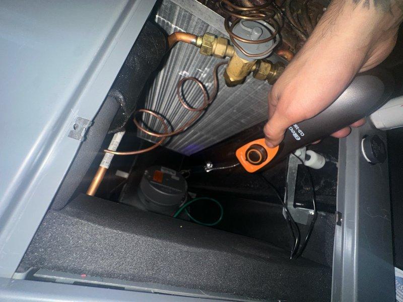 Returned to property to complete refrigerant leak search using electronic leak detector on split system air conditioning unit. Accessed outdoor condenser unit and indoor evaporator coil compartment to systematically test all refrigerant lines, fittings, and brazed connections. Utilized recovery equipment and manifold gauges to isolate system components during leak detection process. Inspected all accessible copper refrigerant lines, service valves, and brass fittings for potential leak points while monitoring detector response.