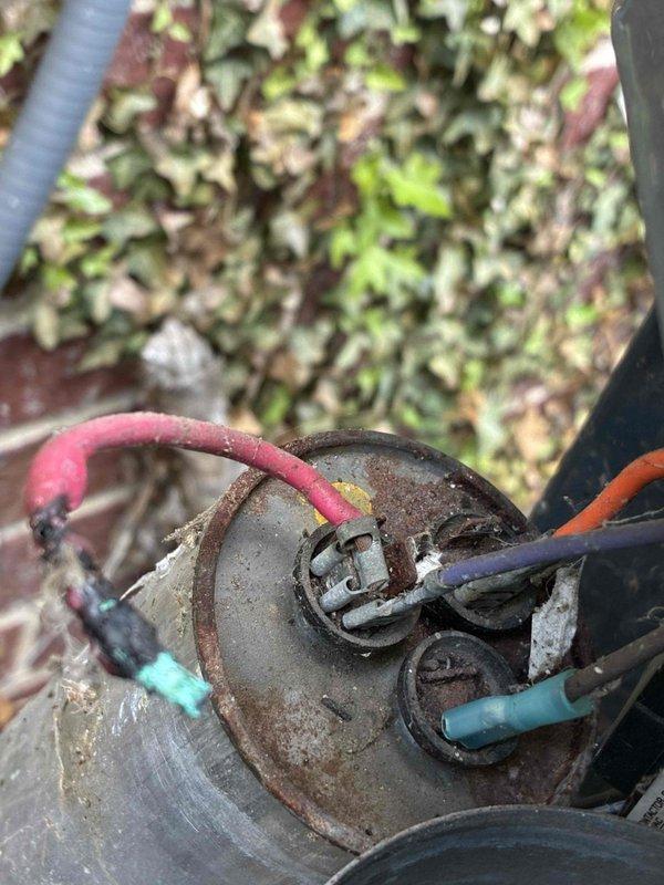 Responded to no cooling complaint on residential air conditioning system. Upon inspection, found dual run capacitor severely corroded and deteriorated, preventing proper compressor and condenser fan motor operation. Replaced failed capacitor with new component, verified proper electrical connections, and tested system operation. Unit now cooling properly with all components functioning within normal parameters.