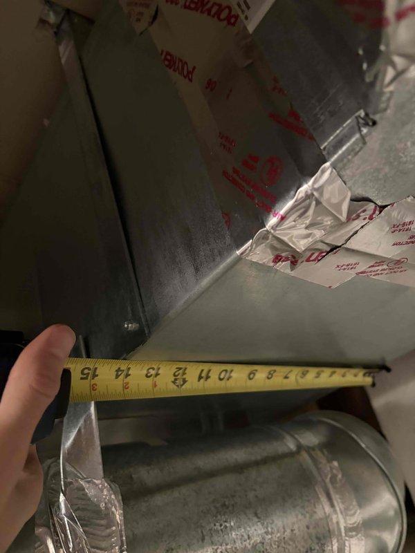 Conducted comprehensive HVAC system assessment for complete replacement of two air conditioning units and one furnace. Performed detailed measurements of existing ductwork to verify compatibility with proposed equipment specifications. Documented current system configuration including three outdoor condenser units positioned along building exterior on concrete pads with electrical connections and conduit routing. Evaluated duct insulation condition and clearances in mechanical space. Assessed installation site accessibility, including brick foundation mounting requirements and existing concrete pad placements. Photographed existing equipment layout and ductwork dimensions to support equipment sizing recommendations and replacement planning. Provided technical specifications and replacement options for complete system upgrade.