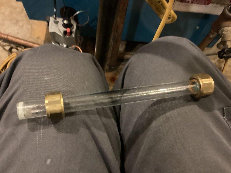 Performed maintenance inspection on single steam boiler system as part of agreement coverage. Removed and inspected boiler sight glass assembly with brass fittings to verify proper water level visibility and component integrity. Documented existing equipment conditions including water level gauge, copper piping connections, valve operations, and associated mechanical components in utility area.