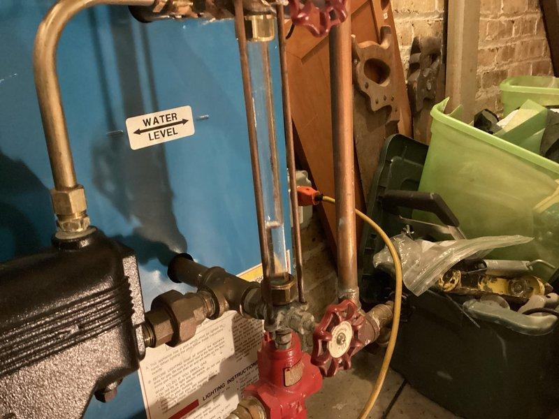 Performed maintenance inspection on single steam boiler system as part of agreement coverage. Removed and inspected boiler sight glass assembly with brass fittings to verify proper water level visibility and component integrity. Documented existing equipment conditions including water level gauge, copper piping connections, valve operations, and associated mechanical components in utility area.