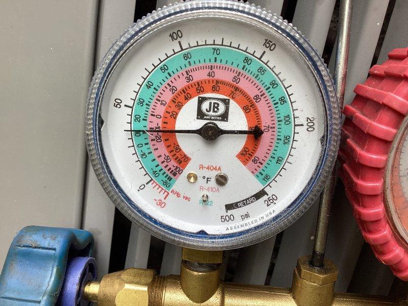 Responded to service call for second opinion on 20-year-old residential air conditioning unit with no cooling condition and suspected refrigerant leak. Upon arrival, performed comprehensive system evaluation including visual inspection of outdoor condensing unit, electrical components, and refrigerant circuit. Connected manifold gauge set to service ports and confirmed low refrigerant charge with abnormal pressure readings on both high and low sides, indicating significant refrigerant loss. Inspected capacitor, contactor, and wiring harness for proper operation and connections. Verified compressor electrical components and control circuits functioning within specifications. Documented system condition with photographs showing pressure gauge readings and internal electrical compartment including Turbo200 capacitor and associated wiring. Confirmed previous diagnosis of refrigerant leak and advised customer that due to advanced age of equipment (20+ years), locating and repairing leak fol