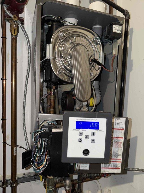 Completed annual maintenance and tune-up service on two residential air conditioning units and one NTI wall-mounted high-efficiency condensing tankless boiler. Performed comprehensive inspection of boiler internal components including stainless steel heat exchanger with vertical ribbing, verified control panel LCD display functionality reading 168 degrees, and examined gas valve, copper piping connections, and electrical wiring systems. Conducted standard preventive maintenance procedures on both AC units to ensure optimal seasonal performance and system efficiency.