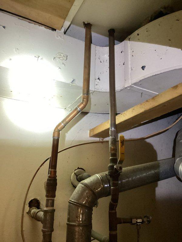Responded to service call for non-functional tanked water heater over 10 years old in residential basement utility room. Upon inspection, assessed existing unit condition and plumbing configuration including copper supply lines, pressure relief valve piping, and associated connections. Determined water heater had reached end of serviceable life and required replacement. Completed full water heater replacement including proper disconnection of existing unit, installation of new tanked water heater with code-compliant connections, pressure relief valve installation with proper discharge piping, and restoration of hot and cold water supply lines using copper piping with appropriate fittings and shut-off valves. Verified all connections for leaks, tested unit operation, and confirmed proper heating function before completing service.