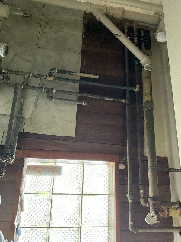 Responded to kitchen sink clog at residential property. Upon arrival, accessed cabinet beneath dual-basin sink to assess drainage system. Inspected white PVC P-trap assembly connected to chrome tailpieces and main vertical drain line. Cleared obstruction from affected drain line, restoring proper water flow and drainage function. Verified both sink basins draining correctly upon completion. System tested and returned to normal operation.