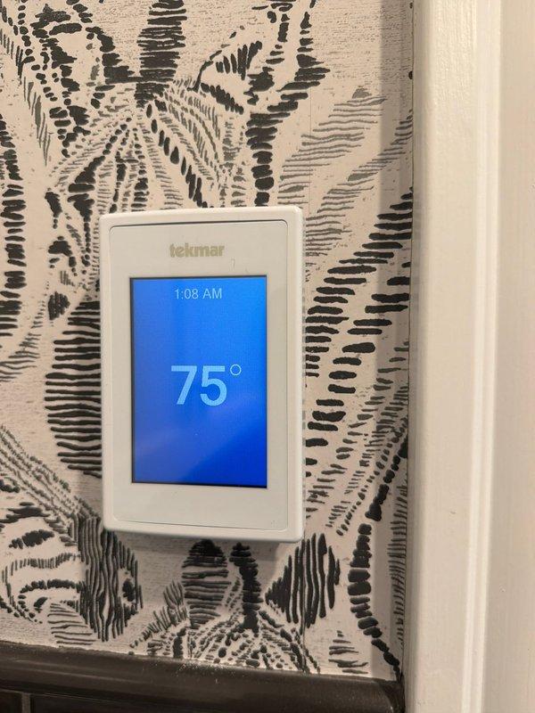 Replaced existing thermostat in master bedroom with new Tekmar 561 digital programmable thermostat. Unit was mounted on interior wall, wired to system, and verified operational with proper temperature display and control functionality.