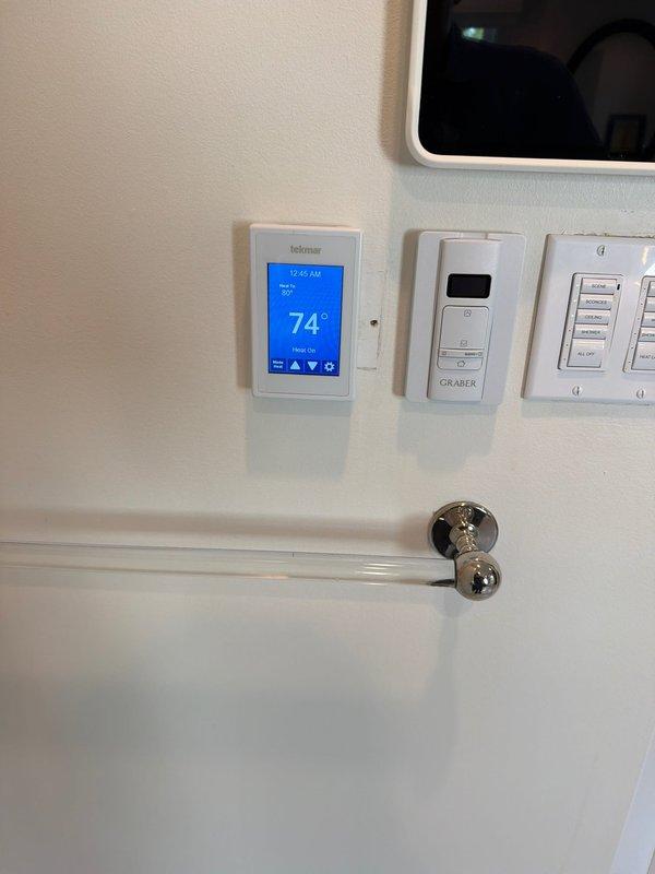 Replaced existing thermostat in master bedroom with new Tekmar 561 digital programmable thermostat. Unit was mounted on interior wall, wired to system, and verified operational with proper temperature display and control functionality.
